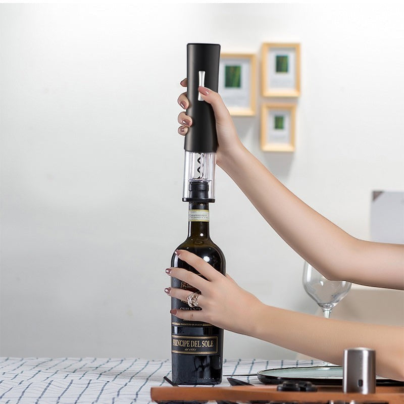 Abrebotellas eléctrico negro Nova Home abriendo una botella de vino tinto con tapa transparente y diseño ergonómico