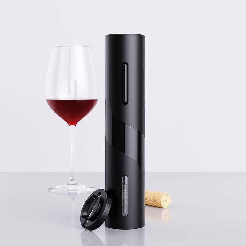 Abrebotellas eléctrico negro Nova Home con cortador de papel aluminio junto a una copa de vino tinto y un corcho