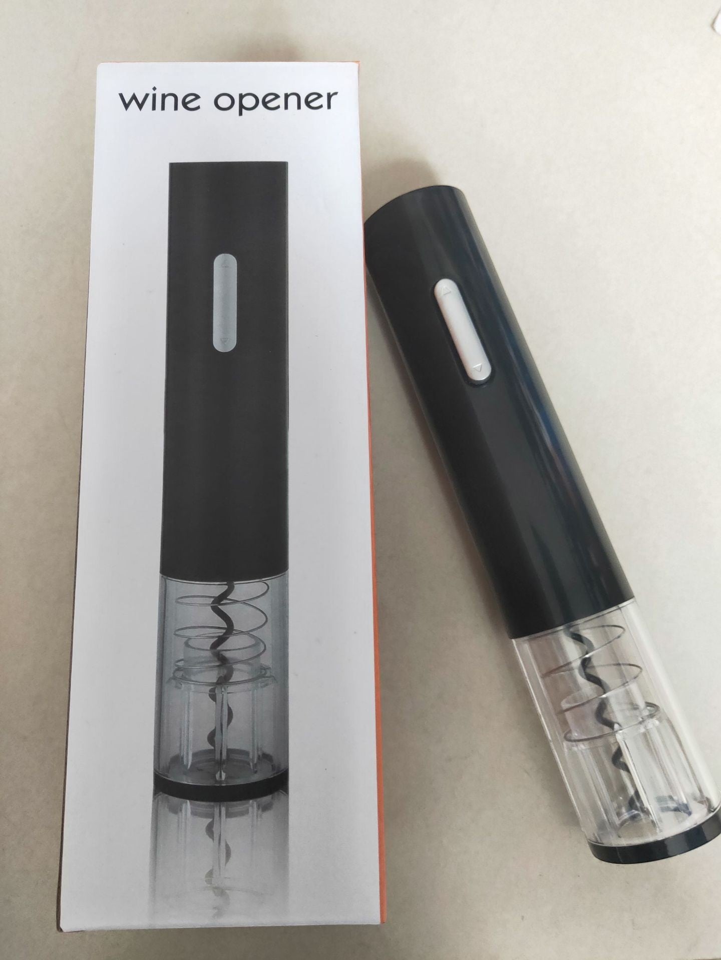 Abrebotellas eléctrico negro Nova Home con sección transparente y sacacorchos visible junto a su caja de embalaje